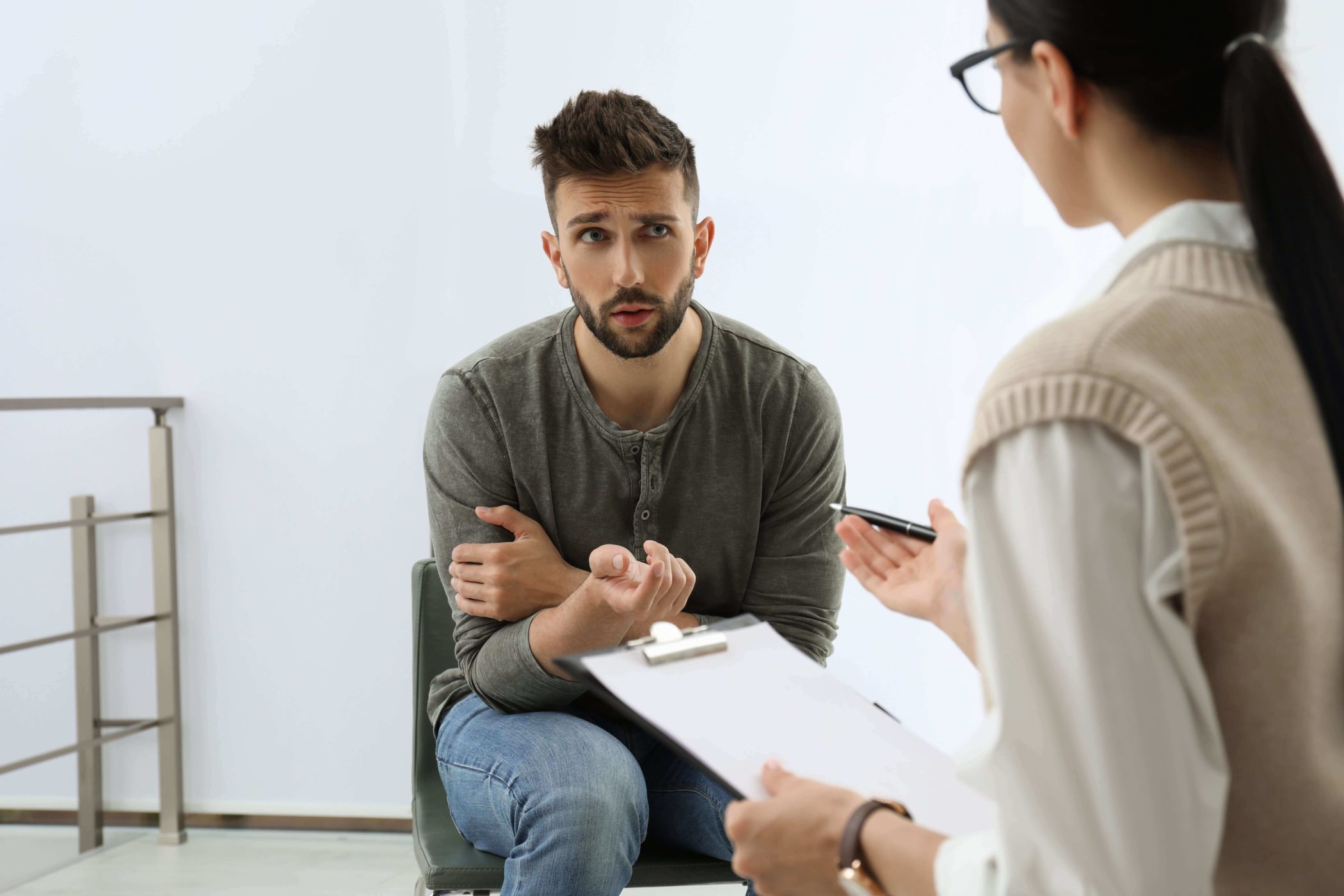 man talking to therapist in rehab
