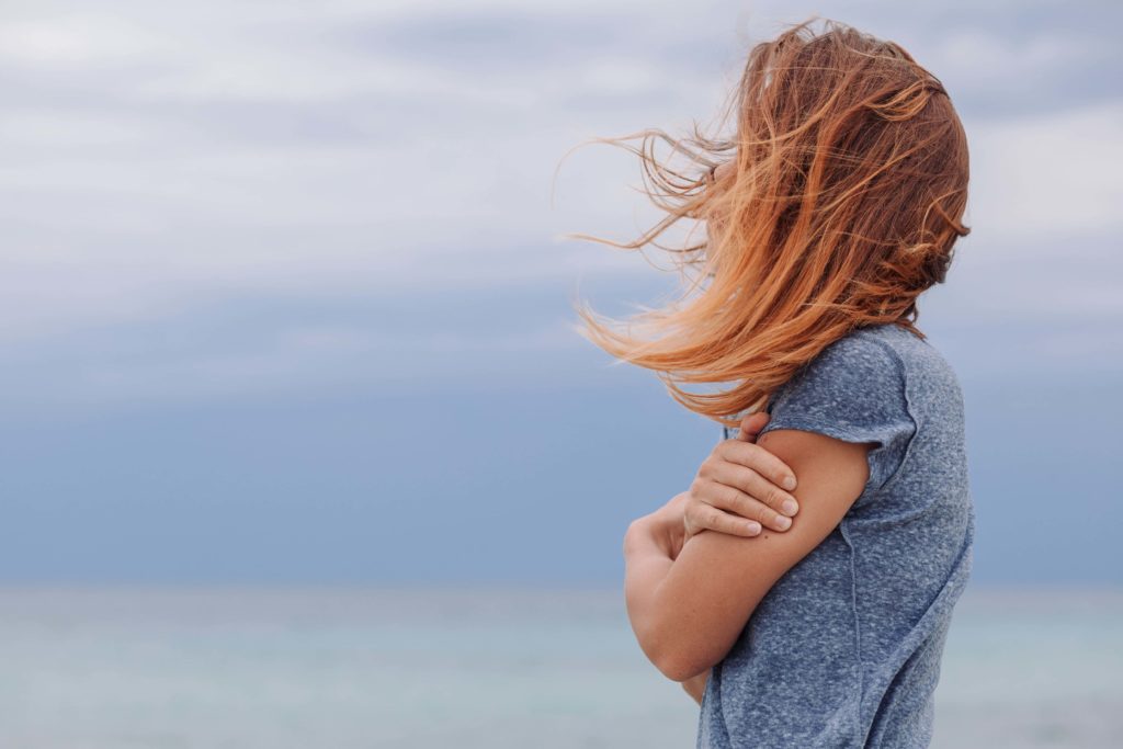 depressed woman feeling lonely looking at the ocean