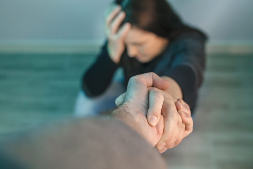 hand helping addicted woman