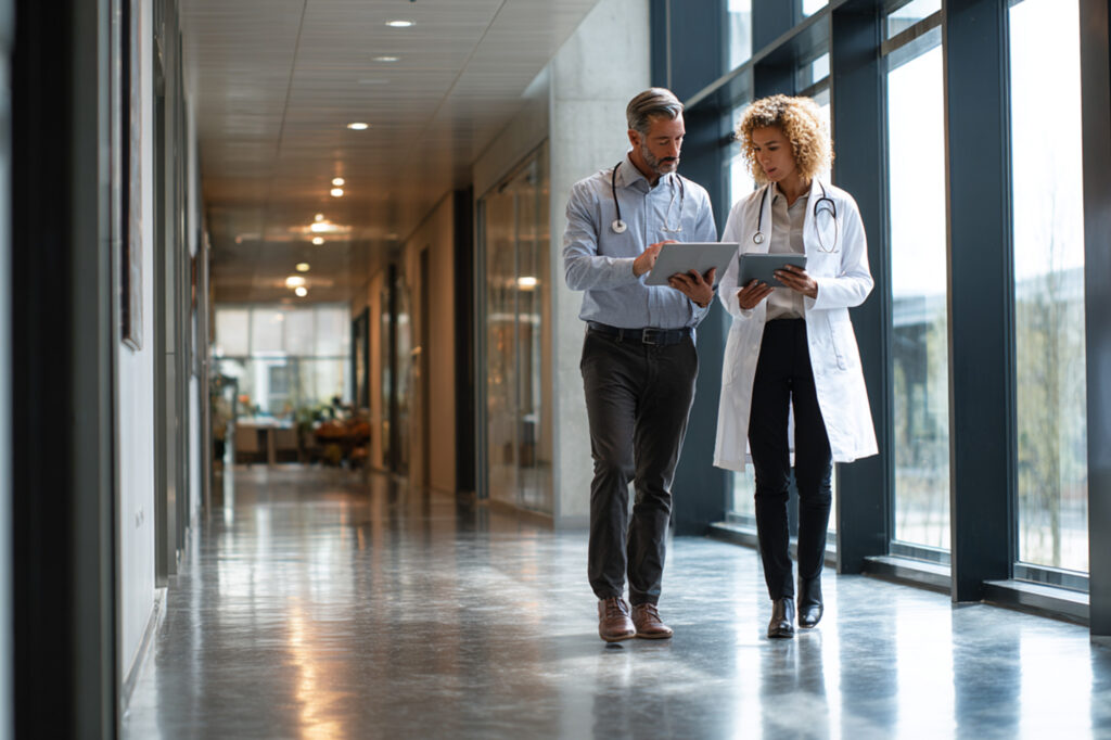 Two doctors having a discussion as they walk down a hall